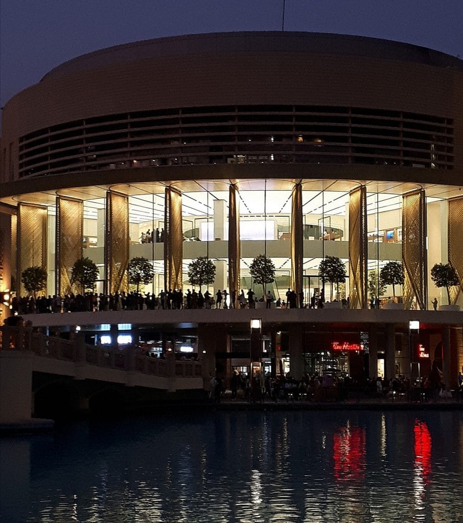 Beleuchtetes Gebäude bei Nacht mit Wasserreflexion.